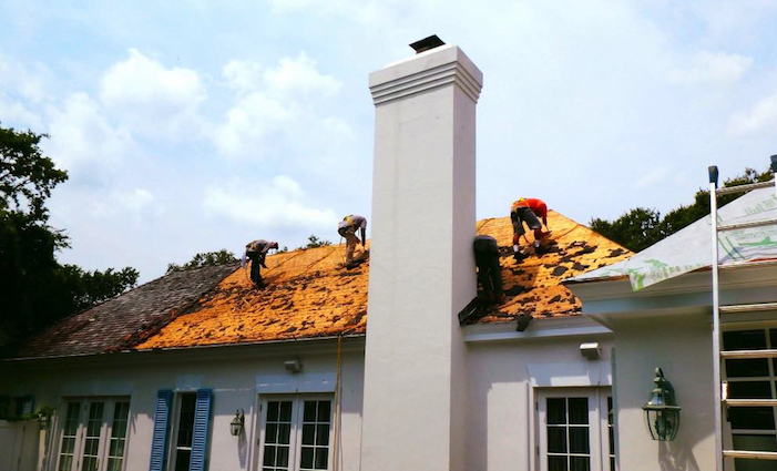 Three roofing contractors are replacing shingles on a home located in Trinity, Pasco County, FL.  Photo courtesy of Nations Roofing.